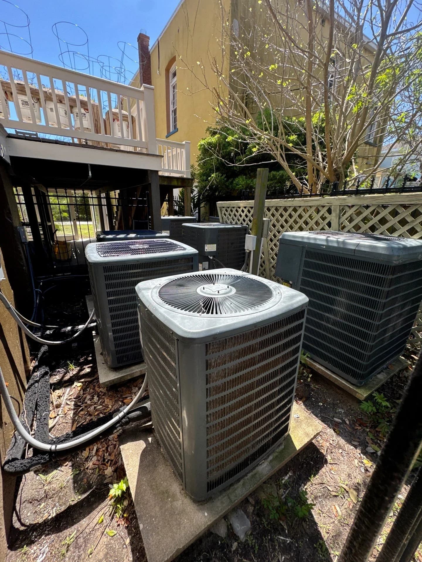 Outdoor AC units at a residential property ready for HVAC maintenance in sunny weather.