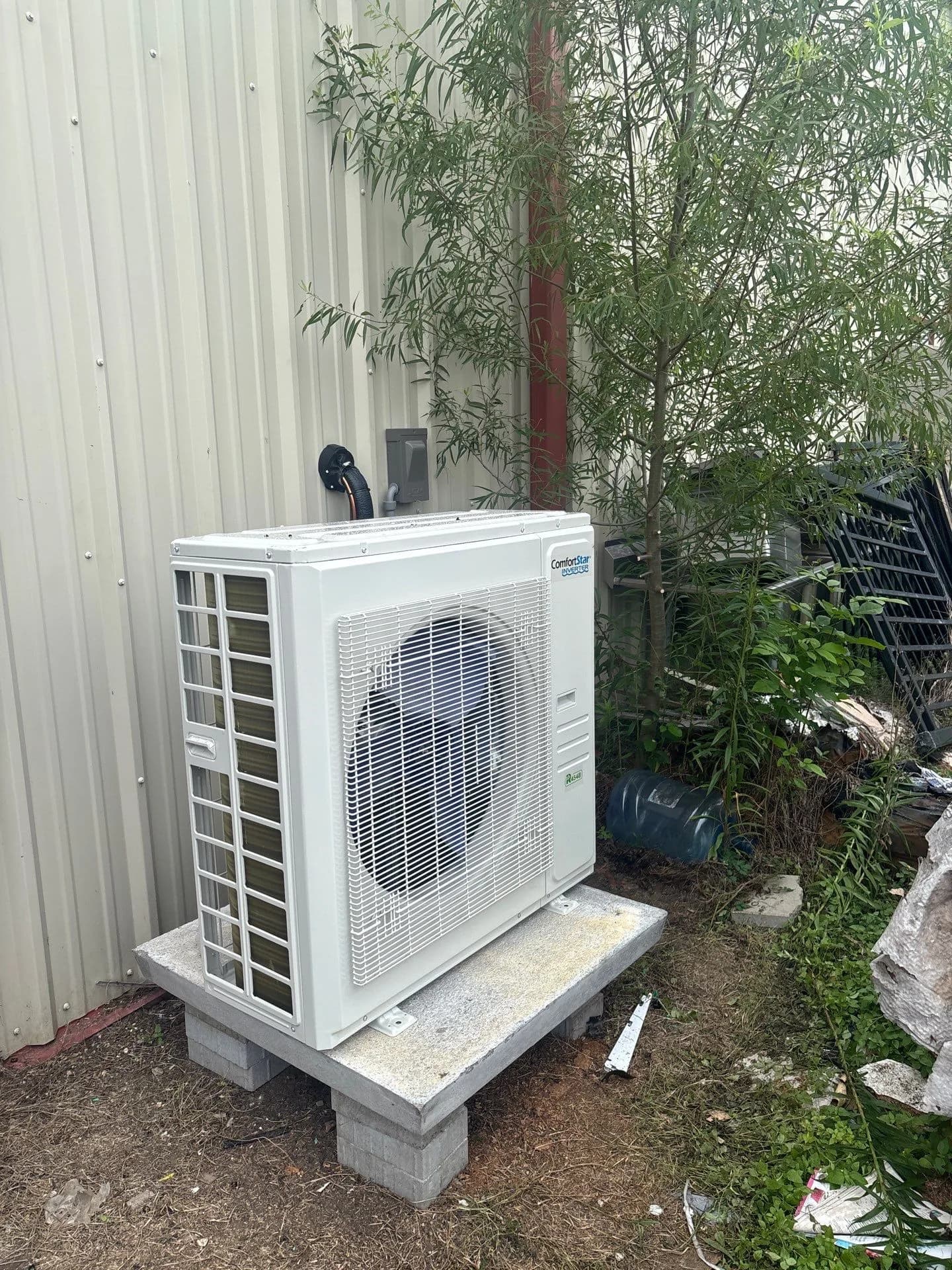 Ductless mini-split system installation at a site with surrounding greenery